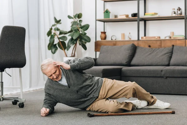 Old men falled down on floor and touching head — Stock Photo
