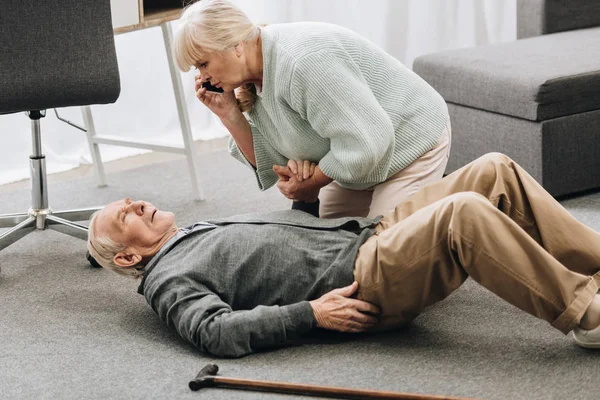 Donna anziana guardando il marito che è caduto con un attacco di cuore e morire — Foto stock