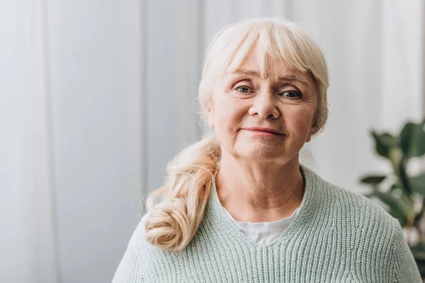 Femme âgée gaie avec des cheveux blonds à la maison — Photo de stock