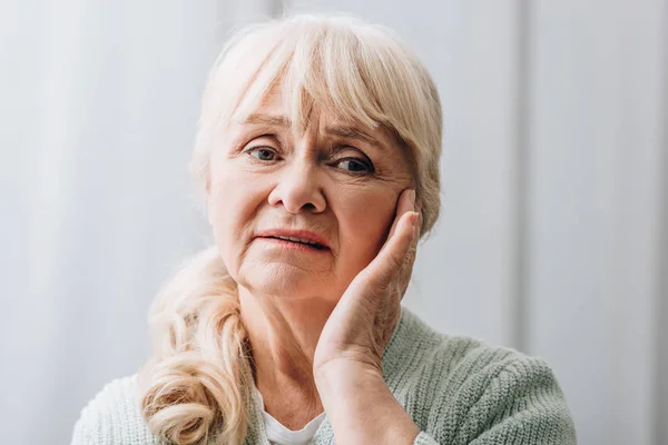 Seniorin mit blonden Haaren hat Kopfschmerzen — Stock Photo