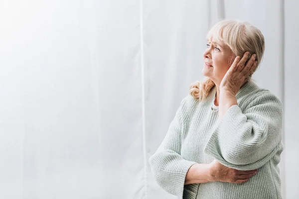 Donna in pensione con capelli biondi con mal di testa — Foto stock