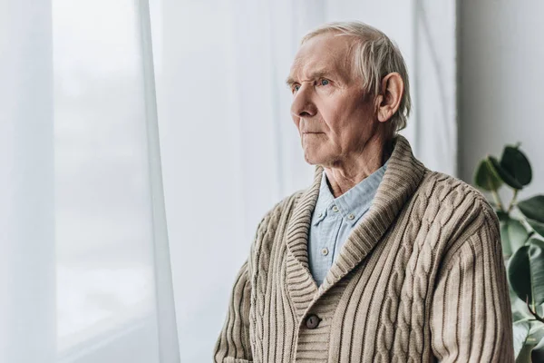 Засмучений пенсіонер з хворобою деменції, що стоїть вдома — стокове фото