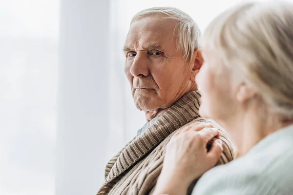 Selektiver Fokus des älteren Ehemannes, der mit seiner Frau im Ruhestand zu Hause steht — Stockfoto