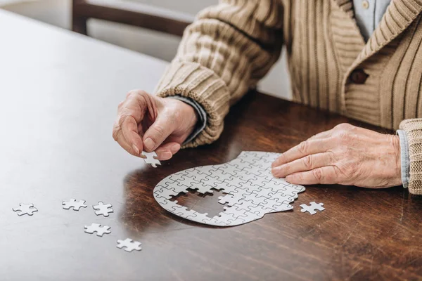 Vue recadrée de l'homme âgé jouant avec des puzzles — Photo de stock