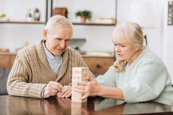 Seniorenpaar spielt Jenga-Spiel zu Hause — Stockfoto