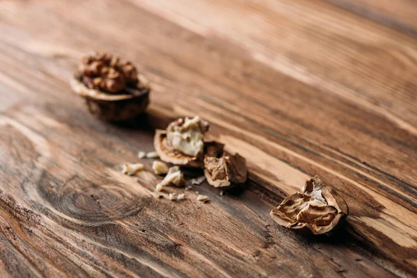 Nozes rachadas em conchas de nozes como símbolo de alzheimer na mesa de madeira — Fotografia de Stock