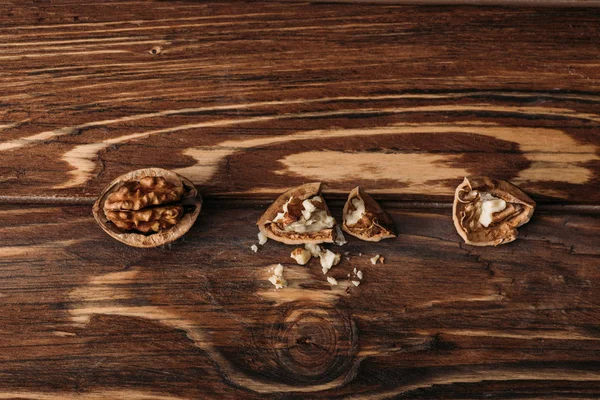 Вид зверху на волоські горіхи в мушлях як символ деменції на дерев'яному столі — стокове фото