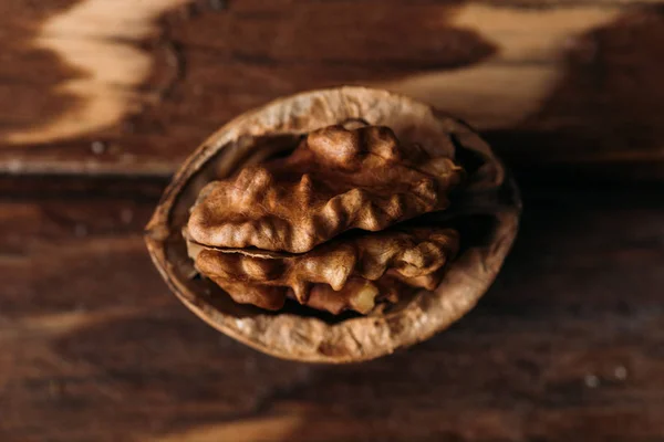 Vue de dessus de noyer dans la coquille de noix comme symbole de démence sur la table en bois — Photo de stock