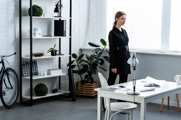 Businesswoman in black formal wear at modern office with copy space — Stock Photo