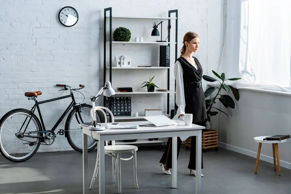 Businesswoman in black formal wear in modern office interior — Stock Photo