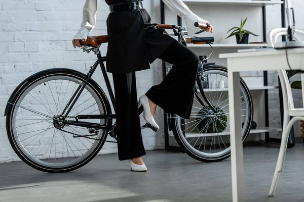 Partial view of woman in black formal wear with bicycle — Stock Photo