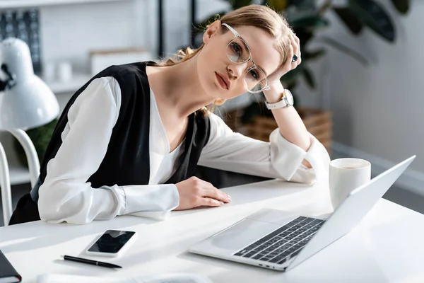 Mulher de negócios cansada no desgaste formal sentado na mesa de computador no local de trabalho — Fotografia de Stock