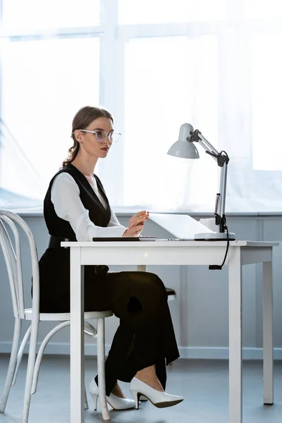 Seriöse Geschäftsfrau in festlicher Kleidung sitzt am Computertisch am Arbeitsplatz — Stockfoto