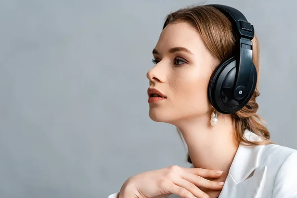 Retrato de mujer hermosa escuchando música en auriculares y mirando hacia otro lado con espacio de copia - foto de stock