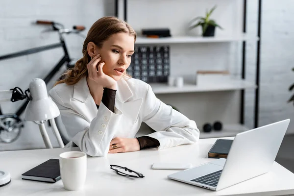 Müde Geschäftsfrau in weißer Festkleidung sitzt am Computer-Schreibtisch am Arbeitsplatz — Stockfoto