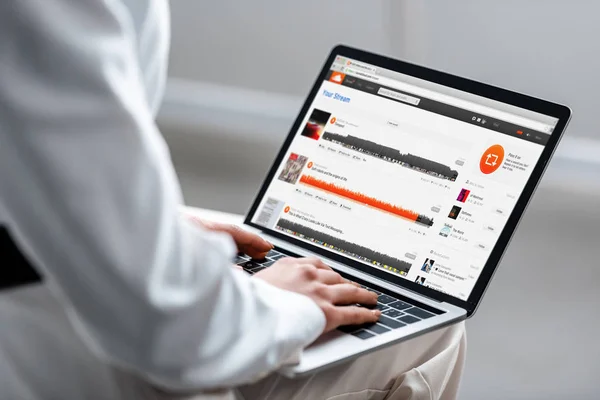 Cropped view of woman using laptop with soundcloud website on screen — Stock Photo