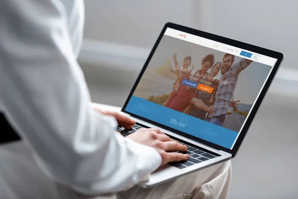 Cropped view of woman using laptop with couchsurfing website on screen — Stock Photo