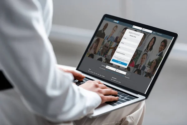 Cropped view of woman using laptop with linkedin website on screen — Stock Photo