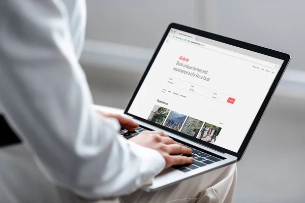 Cropped view of woman using laptop with airbnb website on screen — Stock Photo