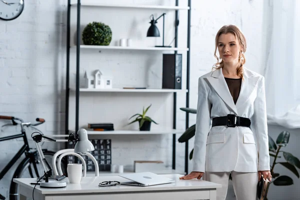 Konzentrierte Geschäftsfrau in formaler Kleidung schaut in modernem Bürointerieur weg — Stockfoto