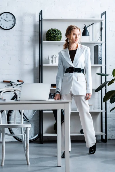 Elegante donna d'affari in bianco abbigliamento formale in interni ufficio moderno — Foto stock