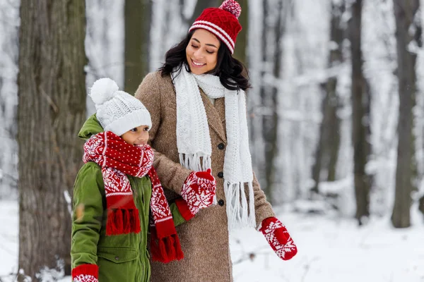 Schöne afrikanisch-amerikanische Frau sieht süße Preteen Kind und lächelt im Winter Park — Stockfoto