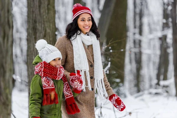 Beautiful african american girl and preteen child walking in winter park — Stock Photo