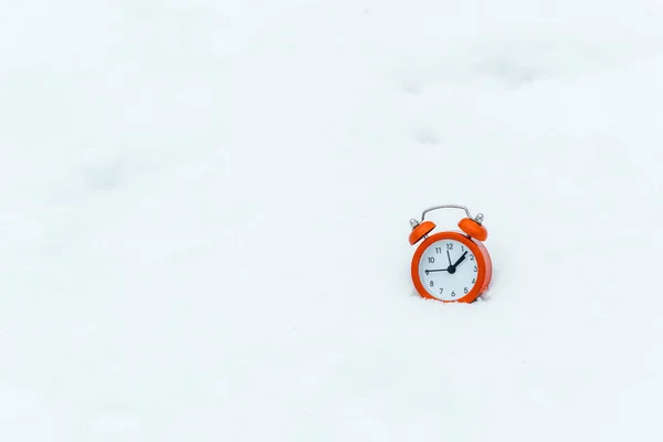 Isolé en blanc du réveil debout sur la neige blanche — Photo de stock
