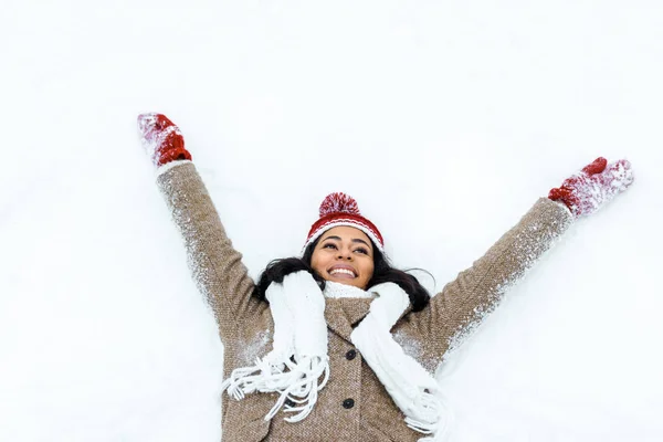 Atractiva mujer afroamericana haciendo ángel de nieve - foto de stock