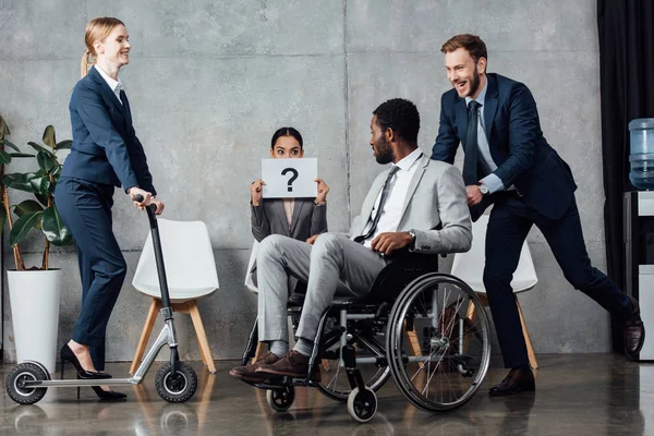 Geschäftsfrau hält Karte mit Fragezeichen auf Hintergrund, während multiethnische Geschäftsleute Spaß beim Treffen haben — Stockfoto