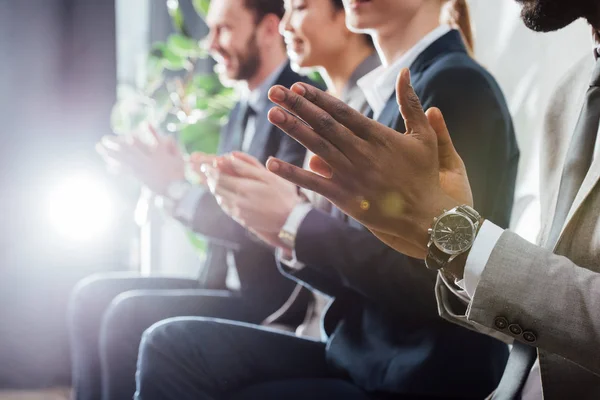 Vue recadrée des applaudissements multiethniques à la réunion avec rétro-éclairé — Photo de stock