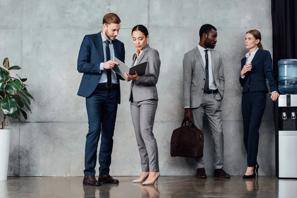 Fokussierte multiethnische Geschäftsleute in formeller Kleidung sprechen im Wartesaal — Stockfoto