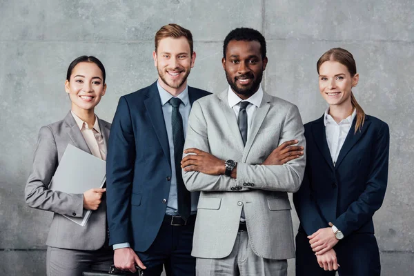 Glückliche multiethnische Gruppe von Geschäftsleuten in formeller Kleidung posiert und blickt in die Kamera — Stockfoto