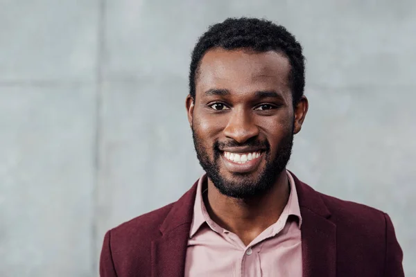 Портрет улыбающегося африканского случайного бизнесмена из Америки на сером фоне — стоковое фото