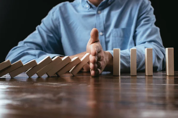 Selective focus of man preventing wooden blocks from falling — Stock Photo