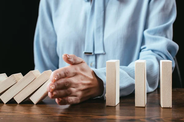 Close up view of woman preventing wooden blocks from falling with hand — Stock Photo