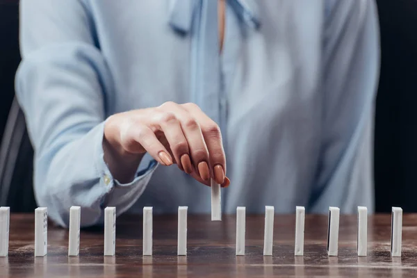 Selective focus of woman picking domino from row on desk — Stock Photo