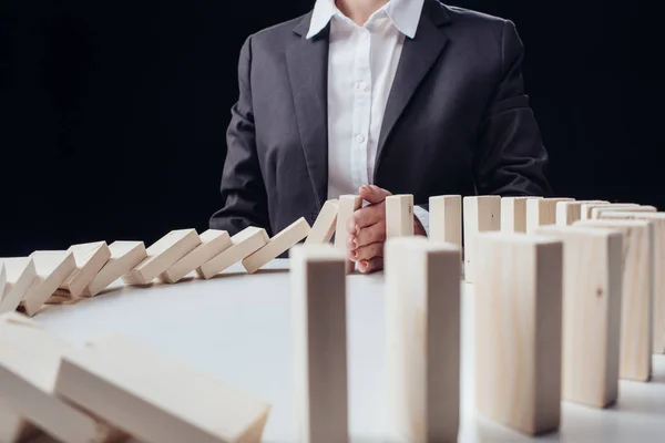 Cropped view of businesswoman preventing wooden blocks from falling — Stock Photo
