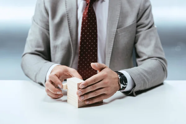 Abgeschnittene Ansicht eines Mannes mit Holzklötzen, die Karriereleiter symbolisieren — Stockfoto