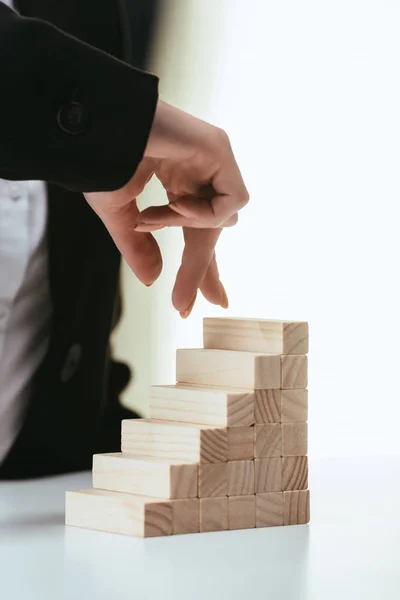 Teilansicht einer Frau, die mit den Fingern auf Holzklötzen geht, die Karriereleiter symbolisieren — Stockfoto