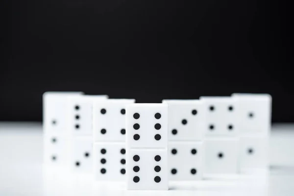 Selective focus of domino row isolated on black with copy space — Stock Photo