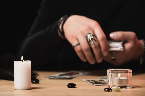 Foco seletivo de velas em chamas com psíquico colocação de cartas de tarô no fundo isolado em preto — Fotografia de Stock