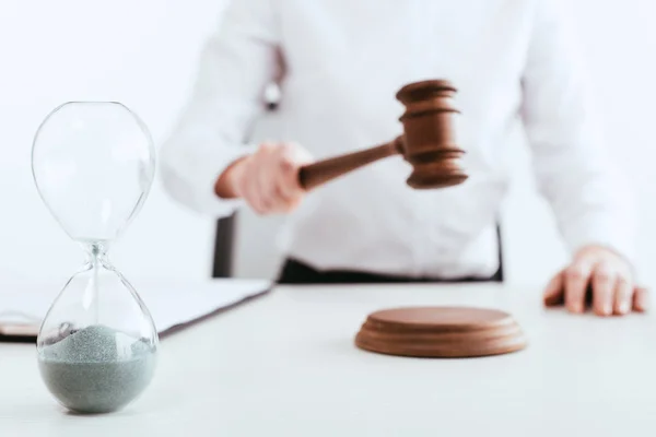 Selective focus of hourglass with running sand with judge on background isolated on white — Stock Photo