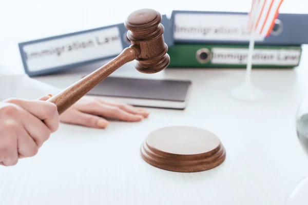 Selective focus of gavel in hand of female judge with folders on background — Stock Photo