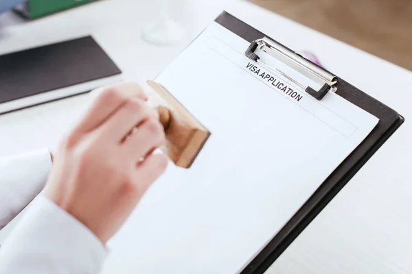 Focus sélectif du presse-papiers avec lettrage de la demande de visa sur le document en main de l'avocate — Photo de stock