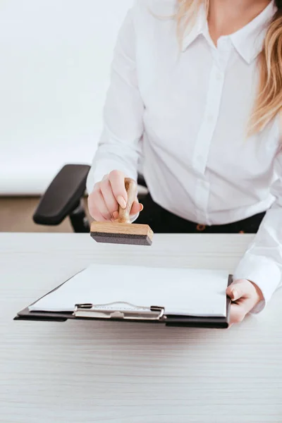 Selective focus of  female lawyer holding clipboard and stamp in hands — Stock Photo