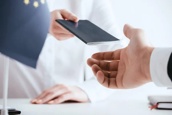 Cropped view of travel agent giving passport to tourist isolated on white — Stock Photo