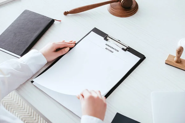 Cropped view of judge holding document with immigration reform lettering near gavel — Stock Photo