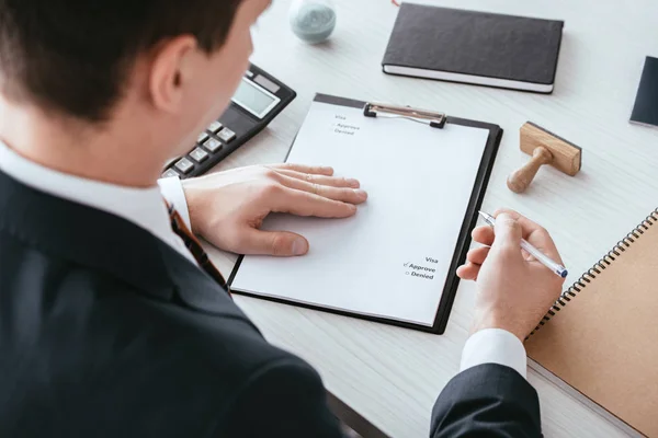 Selektive Fokussierung des Menschen beim Ankreuzen von Kontrollzeichen auf Dokument mit genehmigtem Schriftzug — Stockfoto