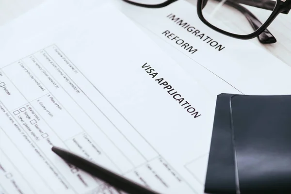 Selective focus documents with lettering near glasses and passports — Stock Photo